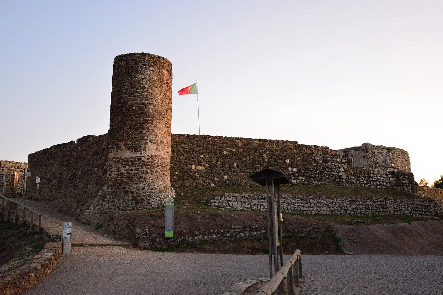 De ronde toren en de muren van het Moorse kasteel van Aljezur met de Portugese vlag
