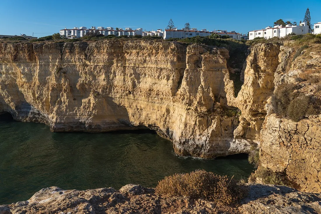 De witte huizen van Carvoeiro bovenop de okerkleurige kliffen langs de kust