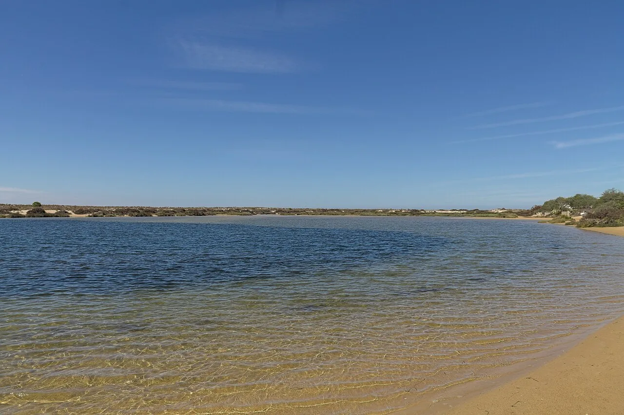 De rustige lagunezijde van Ilha da Armona met ondiep water en een breed zandstrand
