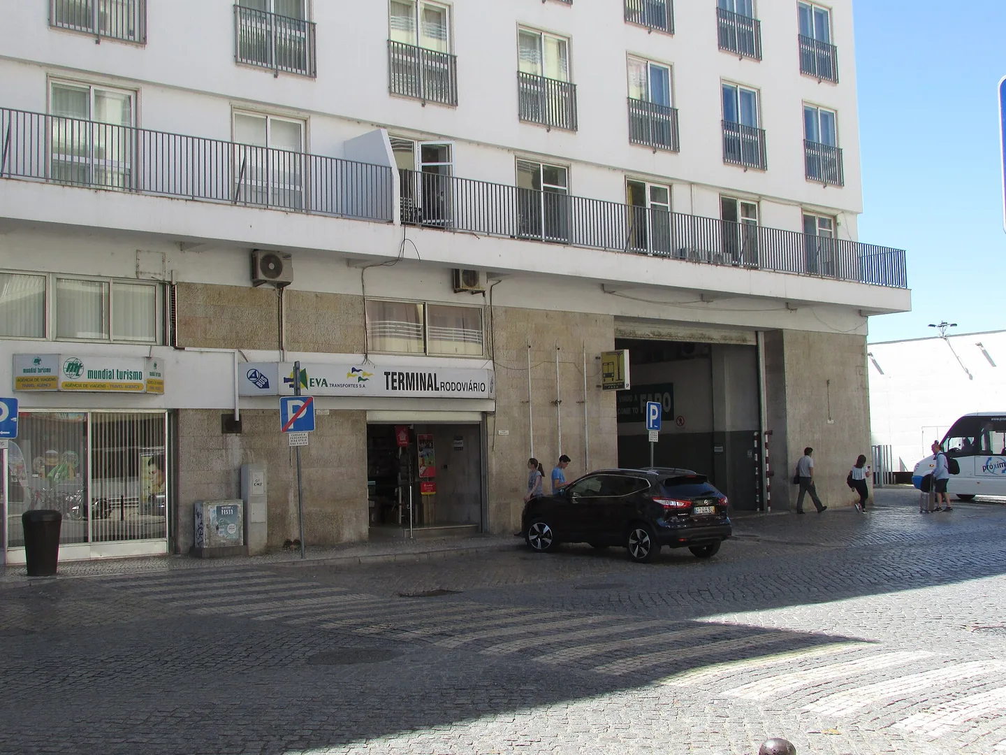 De straatingang van busstation Faro (Terminal Rodoviário) aan de Avenida da República, met het EVA-logo en een bord 'Welcome to Faro'.
