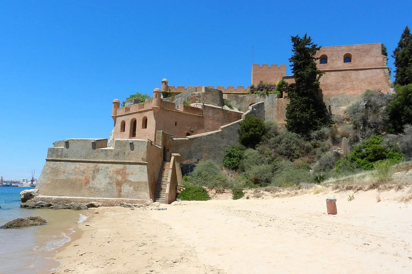 Het Forte de São João do Arade op de rots aan de riviermonding, met zand ervoor
