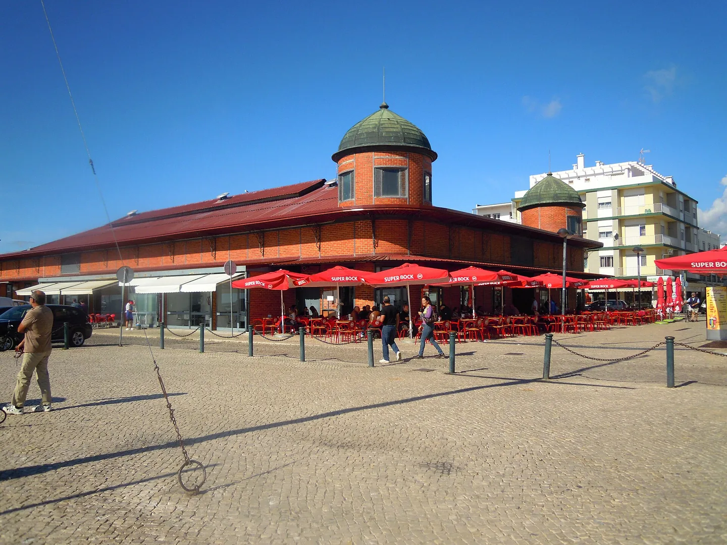 De markt van Olhão van buiten, met terrasjes en parasols langs de kade