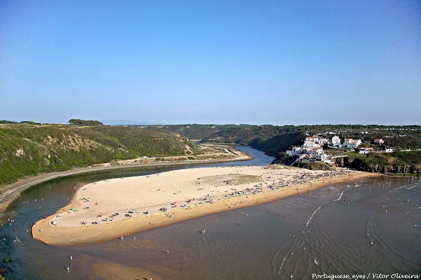 Het hoefijzervormige strand van Odeceixe van bovenaf, waar de rivier de Seixe om het zand naar de oceaan buigt