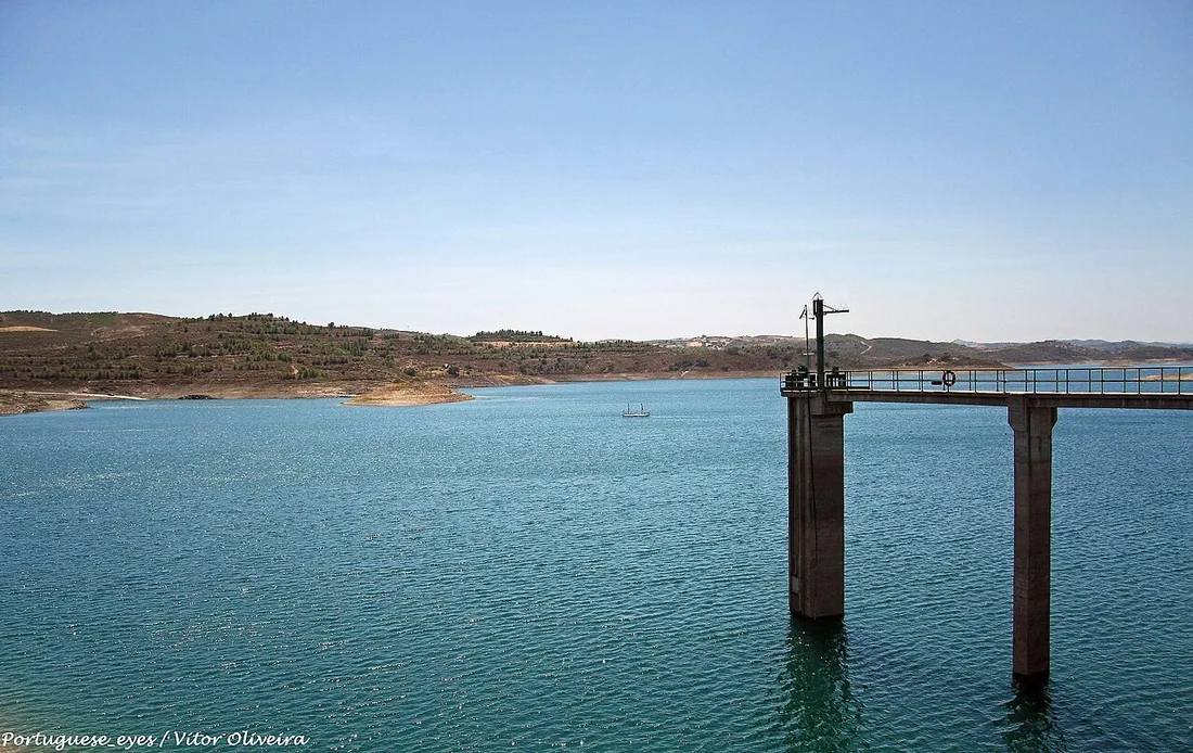 Het stuwmeer Barragem de Odeleite met de dam-inlaat en de kale heuvels van het binnenland