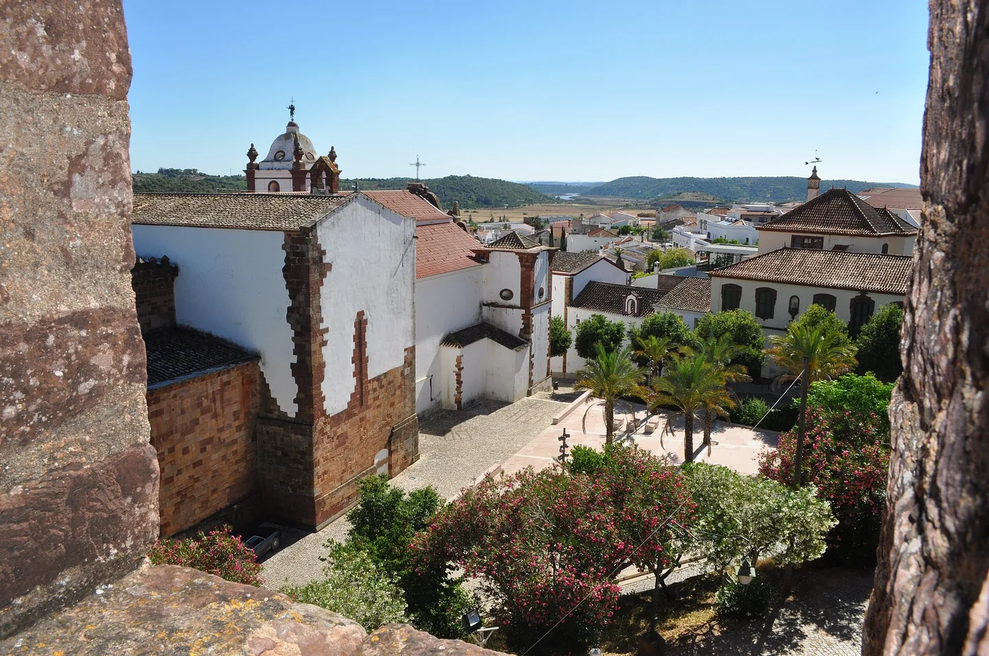 De witte kathedraal van Silves boven de daken van de stad, gezien vanaf de muur van het Moorse kasteel