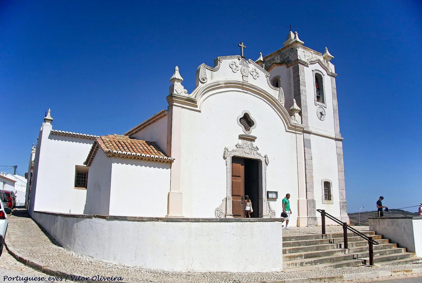 De witte Igreja Matriz van Vila do Bispo tegen een strakblauwe lucht