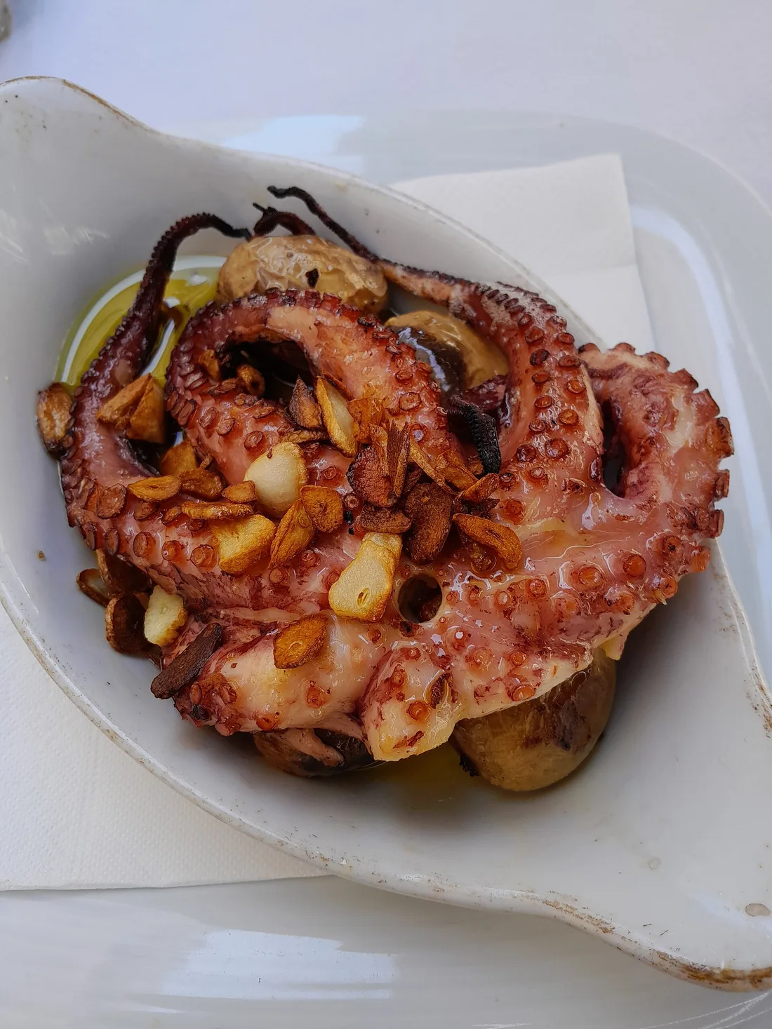 Polvo à lagareiro: gegrilde octopus met aardappelen, olijfolie en knoflook op een bord
