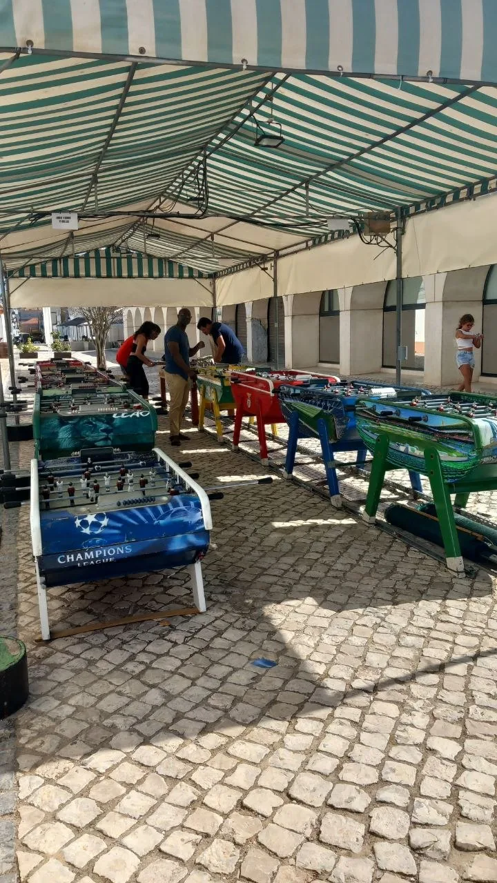 Mannen spelen tafelvoetbal aan de tafels op straat in Vila Real de Santo António