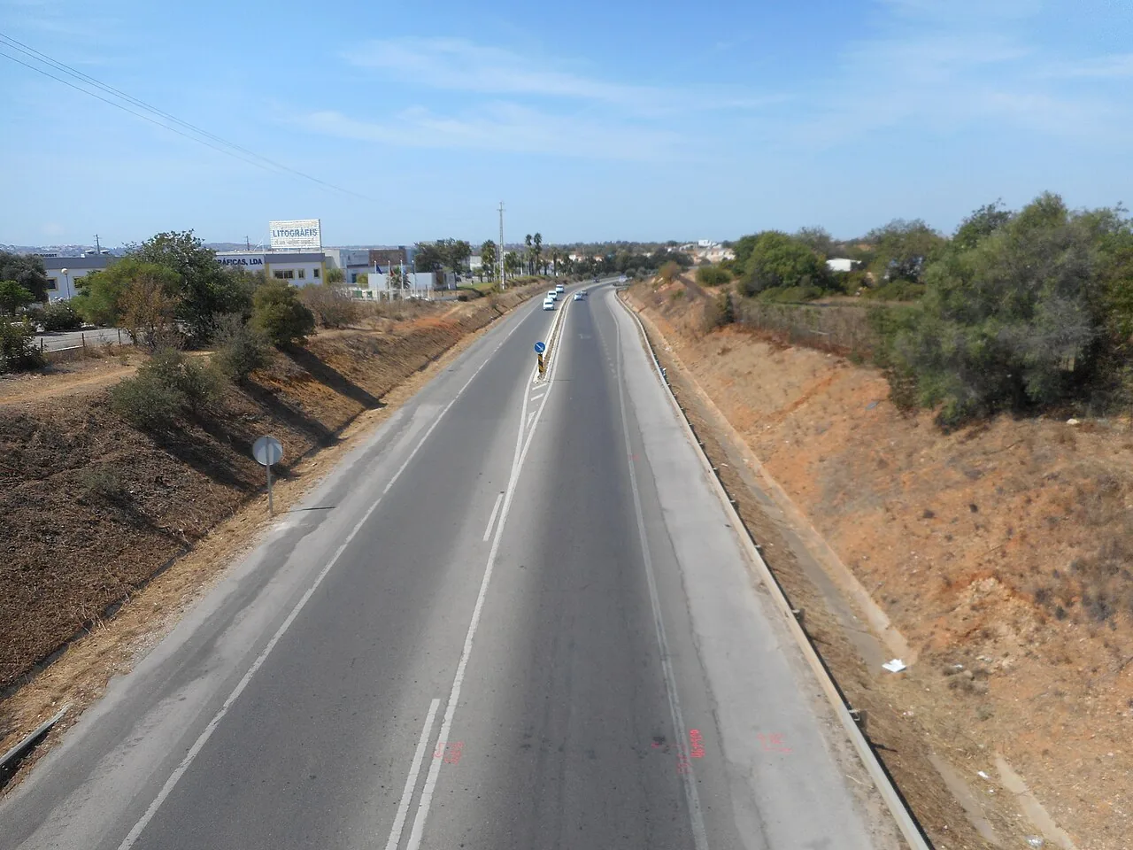 De N125 als rechte tweebaansweg door droog landschap, de oude kustweg van de Algarve